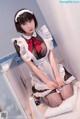 A woman in a maid outfit sitting on a toilet.