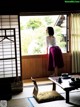 A woman standing in front of a window in a room.