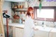 A woman standing in a kitchen next to a sink.