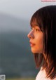 A woman with long hair looking out over the ocean.